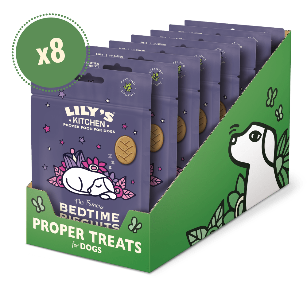 A display of packaged dog treats with a green label featuring an illustration of a dog and text, indicating it is a product for dogs.