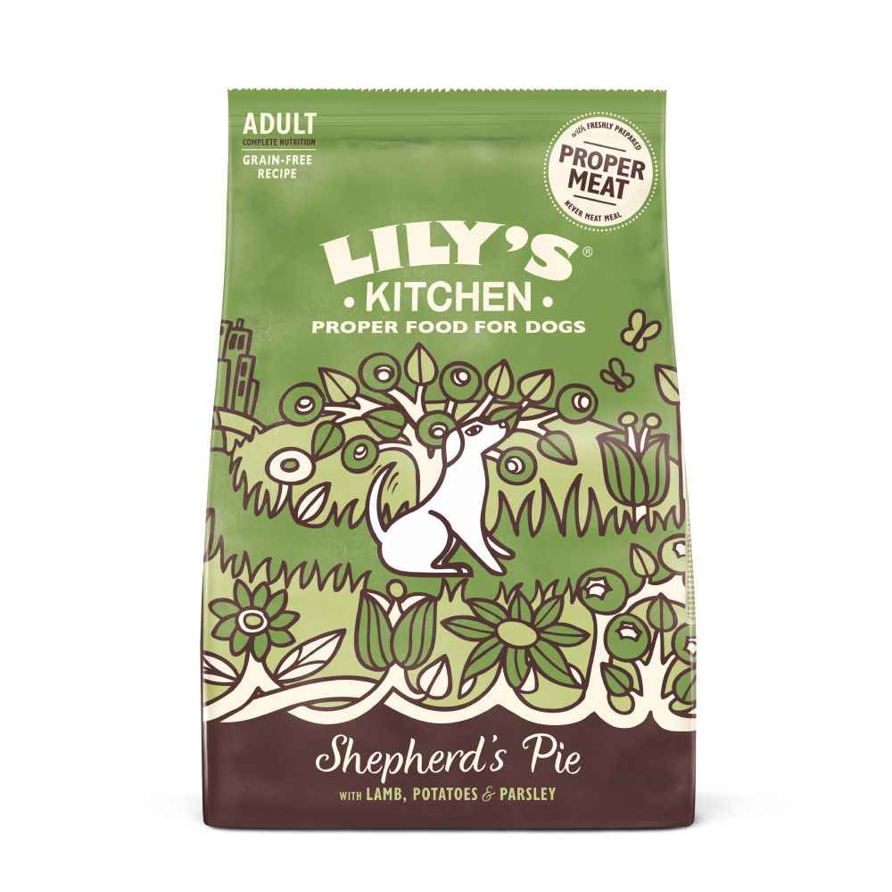 A bag of Lily's Kitchen dry dog food, labeled 'Proper Food for Dogs' with an illustration of a dog and vegetables. The product is for adult dogs with lamb, potatoes, and parsley.